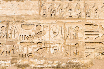 Fototapeta na wymiar It's Hieroglyphs of the Medinet Habu (Mortuary Temple of Ramesses III), West Bank of Luxor in Egypt.