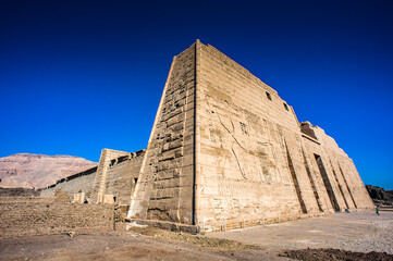 Fototapeta na wymiar It's Wall of the Medinet Habu (Mortuary Temple of Ramesses III), West Bank of Luxor in Egypt.