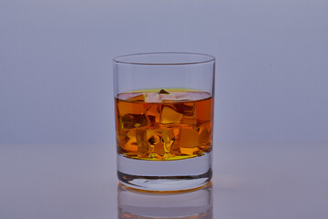 Glass of whisky with ice shot isolated on a white surface.