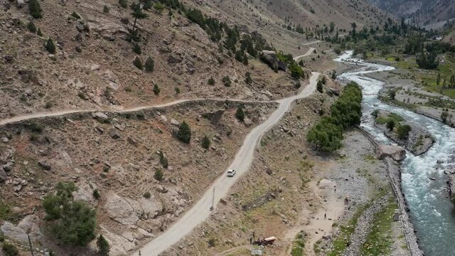 SUV on Curvy Road along Astore River in Valley, North Pakistan, Aerial