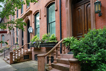 Street with row of elegant old brownstone townhouses or apartment buildings