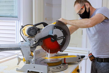 Construction worker wearing a medical mask to prevent Covid-19 is works on remodeling home...
