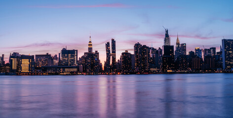 Fototapeta na wymiar Manhattan Midtown skyline panorama view with Empire State building, Chrysler building, American Copper Buildings, Headquarters of the United Nations. Long Exposure photo