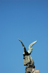 Close View of Angel Statue with wings against blue sky