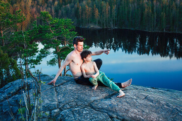 Fototapeta premium middle age man with little cute son doing sport yoga on the top of the mountain together, happy family lifestyle people outdoor, summer wild nature for training