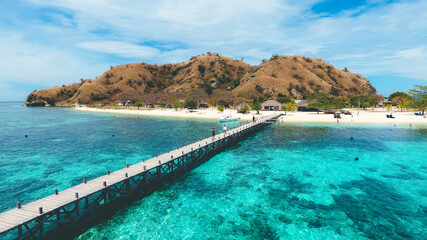 A wooden pier from the coast of Kanawa Island with turquoise sea in, Komodo National Park, Labuan Bajo, Indonesia