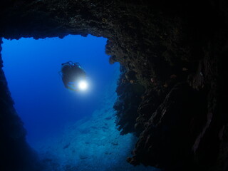 cave diving underwater scuba divers exploring caves ocean scenery sun beams and rays background