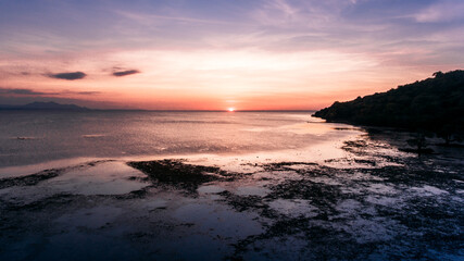 Fototapeta premium Aerial view of low tide beach with beautiful sunset in Ai Lemak Beach, Sumbawa, Indonesia