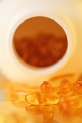 Fish Oil Gelatin Capsules on white packaging blurred background.Omega three fatty acids.Healthy eating and lifestyle.Dietary supplement