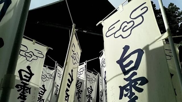 Camera moving backwards through flags with japanese kanji printed on