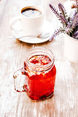 tisane or red herbal tea in a Transparent glass jar on a table outdoors in a tea house in the street