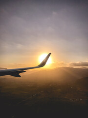 View from the plane of a wing and sunset, over the city and mountains, Chile