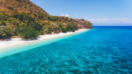 Aerial view of Poto Jarum Beach in Moyo Island, Sumbawa, Indonesia. Beautiful empty beach with with sand and crystal clear sea water