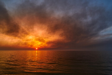 Fototapeta premium Sea sunset. Smoke wildfires sweeping across the sky.