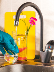 water purification specialist tap water pours into a glass flask.