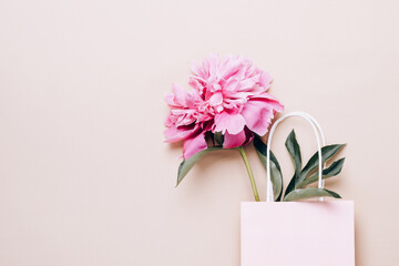 Beautiful pink peony in paper bag. Sale, shopping and eco-friendly packaging concept