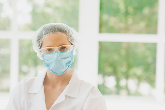 Female Doctor In A Protective Mask And Medical Cap, Closeup Portrait. Widescreen High Resolution Image. Copy Space. Empty Space For Logo Or Text