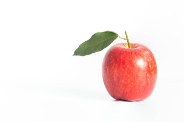 close up of single red apple with leaves