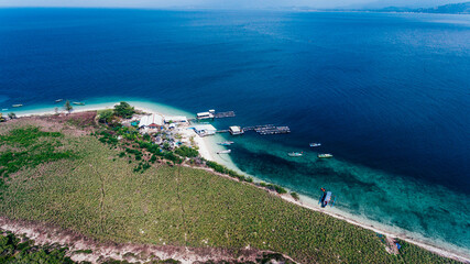 Aerial view of beautiful blue water of sea and the green island in Sumbawa, Indonesia