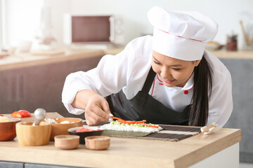 Beautiful Asian chef cooking in kitchen