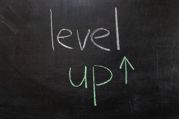 LEVEL UP text on a chalkboard, the concept of raising the level