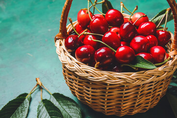 Basket with sweet cherry on color background