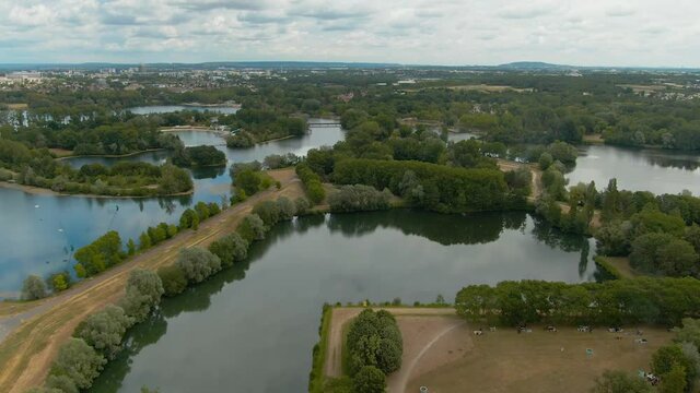Beautiful park of Cergy in France with labyrinth shapes of green forest washed by calm water of lake