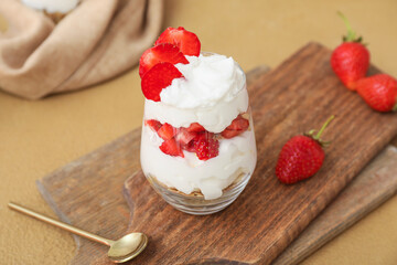 Tasty strawberry dessert in glass on table