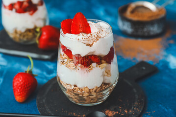 Tasty strawberry dessert in glass on table