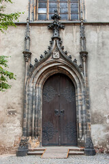 Fototapeta na wymiar Old church textured door with stone arch facade