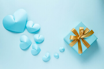 青いギフトボックスと金色のリボンと青いハート