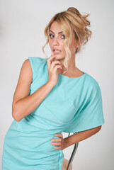 Portrait of a young beautiful woman in a light blue dress posing in the studio