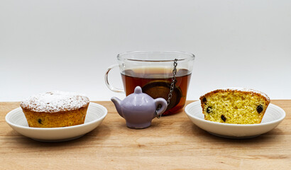 Freshly homemade muffins and a cup of tea on wooden table