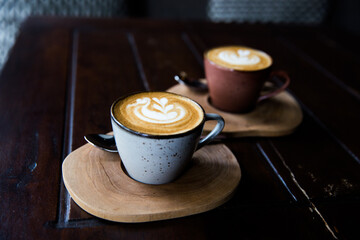Two Cups of hot cappuccino on wooden desk background.