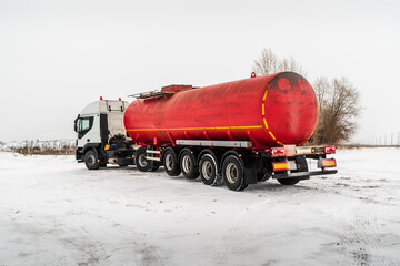 Oil tanker truck with a tank semi-trailer on a winter road. The picture was taken in Russia in winter