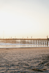 Fototapeta na wymiar Pier in California during the sunset. A typical American pier on the Pacific coast - a favorite vacation spot of families