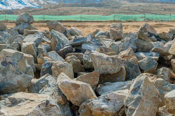 Pile of large granite boulders at new construction site.