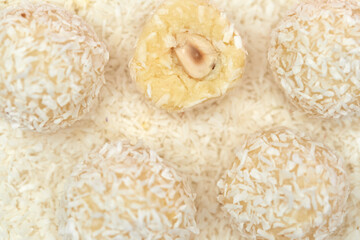 close-up, candies covered by shredded coconut. coconut balls with coconut flakes. top view