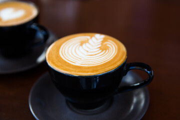 Two Cups of hot cappuccino on wooden desk background.