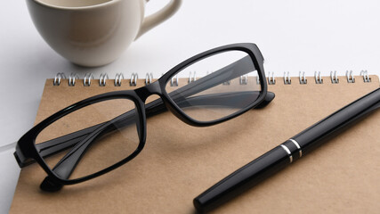 pen and glasses on a notebook