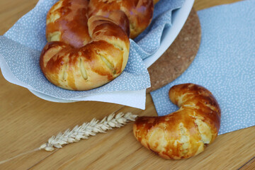 Fresh homemade croissants with marmelade on a plate on wooden table