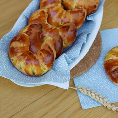 Fresh homemade croissants with marmelade on a plate on wooden table