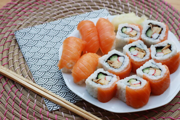 Sushi California rolls with ginger and chopsticks on a plate on wooden table. Delicoius Sushi food