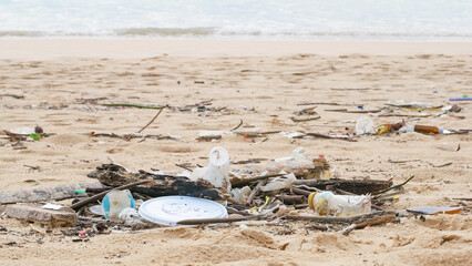 Environmental pollution. Ecological problem. Garbages, plastic, and wastes on the sandy beach of tropical sea.