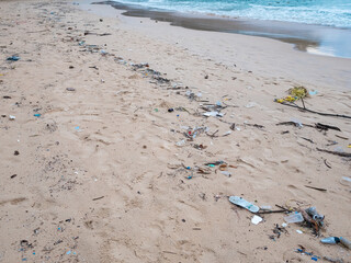 Environmental pollution. Ecological problem. Garbages, plastic, and wastes on the sandy beach of tropical sea.