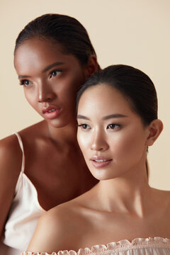 Beauty. Ethnic Women Portrait. Different Ethnicity Girls With Natural Makeup And Perfect Skin Against Beige Background. Beautiful Multicultural Mixed Race And Asian Models Looking Away.