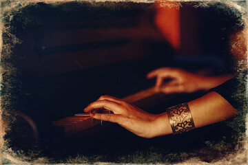 Woman's hands on the keyboard of the piano closeup. Old photo effect