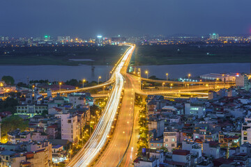 Hanoi cityscape with modern buildings on Minh Khai street with Vinh Tuy bridge at twilight