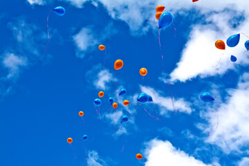 Balloons orange and blue in sky