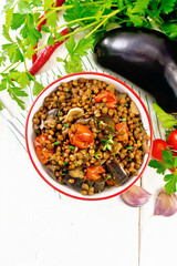 Lentils with eggplant in bowl on light board top
